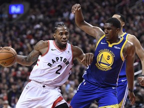 Toronto Raptors forward Kawhi Leonard (2) drives up court as Golden State Warriors centre Kevon Looney (5) defends during second half basketball action in Game 1 of the NBA Finals in Toronto on Thursday, May 30, 2019.
