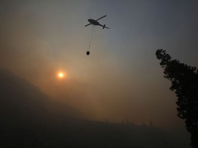 File - In this Aug. 14, 2018, file photo, a fire helicopter takes off through smoke rising to make a drop on active fires in Yosemite National Park, Calif. The National Interagency Fire Center is predicting a heavy wildfire season for areas along the west coast of the United States this summer. The Boise, Idaho-based center said Wednesday, May 1, 2019, that most of the country can expect a normal wildfire season in the period from May through August.