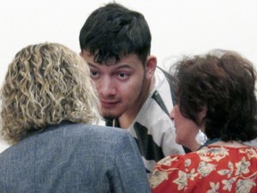 FILE - In this Jan. 24, 2019 file photo, Wilber Ernesto Martinez-Guzman, of El Salvador, talks to his public defender and interpreter during his initial appearance in Carson City Justice Court in Carson City, Nev. Nevada prosecutors are defending their handling of a confession presented to the grand jury that indicted the Salvadoran immigrant on four murder charges during a week-long killing rampage in January. They're also providing more details about why they believe they have the authority to try him in one place for crimes that occurred in different counties.