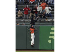 San Francisco Giants left fielder Mac Williamson jumps as fans reach for a solo home run by Arizona Diamondbacks' Ildemaro Vargas during the first inning of a baseball game in San Francisco, Friday, May 24, 2019.