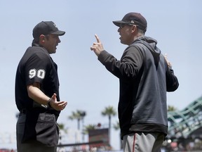Arizona Diamondbacks manager Torey Lovullo, right, gestures while talking with umpire Mark Ripperger (90) before challenging a play during the first inning of a baseball game against the San Francisco Giants in San Francisco, Saturday, May 25, 2019.