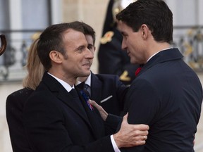 French President Emmanuel Macron greets Prime Minister Justin Trudeau as he arrives in Paris, France Sunday November 11, 2018.