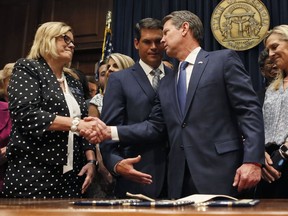 Georgia's Republican Gov. Brian Kemp, right, shakes hands with state Sen. Renee Unterman, R-Buford, after signing legislation, Tuesday, May 7, 2019, in Atlanta, banning abortions once a fetal heartbeat can be detected, which can be as early as six weeks before many women know they're pregnant. Kemp said he was signing the bill "to ensure that all Georgians have the opportunity to live, grow, learn and prosper in our great state."