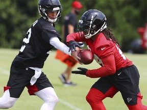 Atlanta Falcons quarterback Matt Ryan, left, hands off to running back Devonta Freeman during NFL football practice, Thursday, May 23, 2019, in Flowery Branch, Ga.