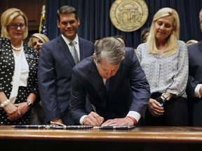 FILE - In this May 7, 2019, file photo, Georgia's Republican Gov. Brian Kemp, center, signs legislation in Atlanta, banning abortions once a fetal heartbeat can be detected, which can be as early as six weeks before many women know they're pregnant. Georgia became the fourth state to enact the ban on abortions after a fetal heartbeat can be detected.