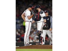 Atlanta Braves pitcher Jesse Biddle, left, talks with catcher Brian McCann as pitching coach Rick Kranitz approaches the mound after a wild pitch in which St. Louis Cardinals' Kolten Wong scored during the fifth inning of a baseball game Tuesday, May 14, 2019, in Atlanta.