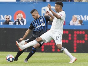 Montreal Impact's Saphir Taider, left, is challenged by New England Revolution's Juan Agudelo during second half MLS soccer action in Montreal, Saturday, May 18, 2019.