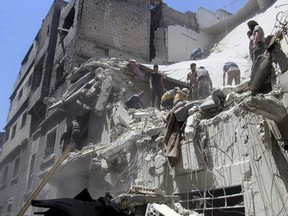 This photo provided by the Syrian Civil Defense White Helmets, which has been authenticated based on its contents and other AP reporting, shows Civil Defense workers inspecting a damaged building after an airstrike by Syrian government forces, in the town of Ariha, in the northwestern province of Idlib, Syria, Monday, May 27, 2019. Syria's White Helmets say at least six people were killed and 10 remain under rubble following government air raids on a town in the rebel's last stronghold. (Syrian Civil Defense White Helmets via AP)