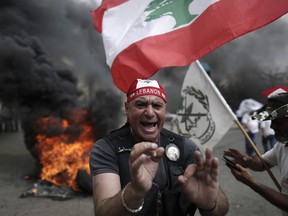 Lebanese retired soldiers protest in front of the government building during a cabinet meeting to discuss an austerity budget, in Beirut, Lebanon, Friday, May 10, 2019. Dozens of Lebanese military and security veterans burned tires and shouted angrily outside government offices on Friday, their second protest in less than two weeks amid fears a proposed austerity budget may affect their pensions and benefits.
