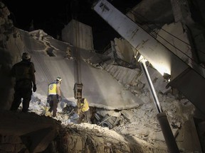 This photo posted on Tuesday, May 28, 2019 and provided by the Syrian Civil Defense White Helmets, which has been authenticated based on its contents and other AP reporting, shows Civil Defense workers searching for victims under the rubble of a destroyed building after an airstrike by Syrian government forces, in the town of Ariha, in the northwestern province of Idlib, Syria. Syrian activists and rescuers say government warplanes and artillery have pounded the last rebel stronghold in the country, killing over a dozen people. (Syrian Civil Defense White Helmets via AP)