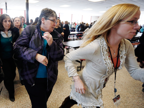 Participants rush out of the cafeteria after hearing gun shots during a lockdown drill at Milford High School in Milford, Mass.