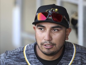 In this Monday, May 13, 2019 photo, Quad Cities River Bandits manager Ray Hernandez stands in the dugout before a Class-A Midwest League baseball game against the Cedar Rapids Kernels in Cedar Rapids, Iowa. Quad Cities will play at least 40 of their first 43 games away from their home stadium Modern Woodmen Park because of water issues caused by flooding from the nearby Mississippi River.