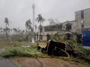 An auto-rickshaw and uprooted trees lie along a road in Puri district after cyclone Fani hit the coastal eastern state of Odisha, India, Friday, May 3, 2019.