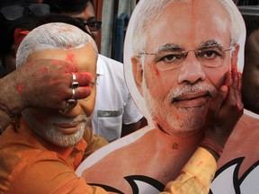 A Bharatiya Janata Party (BJP) supporter puts vermillion powder on a cutout of Narendra Modi during celebrations of the party's victory in Kolkata, India, Thursday, May 23, 2019.