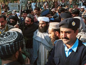 FILE - In this Jan. 27, 2000 file photo, Masood Azhar, center, wearing glasses and white turban, leader of Jaish-e-Mohammad arrives in Islamabad, Pakistan. Pakistan's Foreign Ministry said Wednesday, May 1, 2019, that Azhar, the leader of an outlawed militant group blamed by India for a February suicide attack that killed 40 of its soldiers has been added to a United Nations sanctions blacklist by the Security Council.