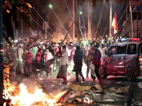 Fire crackers explode near supporters of presidential candidate Prabowo Subianto during clashes with the police in Jakarta, Indonesia, Wednesday, May 22, 2019. Indonesian President Joko Widodo said authorities have the volatile situation in the country's capital under control after six people died Wednesday in riots by supporters of his losing rival in last month's presidential election.