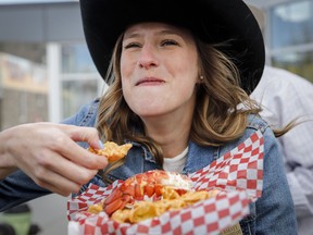 Sabryna Harvey samples "Creamy Truffle Lobster Dumplings," as the Calgary Stampede announced 50 new midway foods marking 50 days until the annual event in Calgary, Alta., Wednesday, May 15, 2019.THE CANADIAN PRESS/Jeff McIntosh