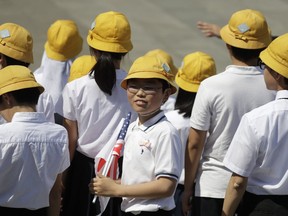 School children wait for President Donald Trump and first lady Melania Trump to arrive participate in a welcome ceremony at the Imperial Palace, Monday, May 27, 2019, in Tokyo.