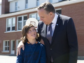 Quebec Premier Francois Legault , right, meets sixth grader student James Paquet to announce the building of a new school after it was flooded by the Chaudiere River in Scott, Que., Monday, May 6, 2019. Paquet, of the L'Accueil school, composed a song destined to Premier Legault telling of his flooded school. The song became viral on the web and Paquet's wish was granted.