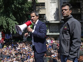 Venezuelan opposition leader and self-proclaimed acting president Juan Guaido (C) speaks to supporters next to high-profile opposition politician Leopoldo Lopez, who had been put under home arrest by Venezuelan President Nicolas Maduro's regime, and members of the Bolivarian National Guard who joined his campaign to oust Maduro, in Caracas on April 30, 2019.