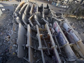 Palestinians check the damage of a destroyed multi-story building was hit and destroyed on Sunday by Israeli airstrikes, in Gaza City, Monday, May. 6, 2019. The Israeli military has lifted protective restrictions on residents in southern Israel while Gaza's ruling Hamas militant group reported a cease-fire deal had been reached to end the deadliest fighting between the two sides since a 2014 war.
