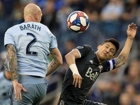 Sporting Kansas City defender Botond Barath (2) heads the ball over Vancouver Whitecaps forward Fredy Montero, right, during the first half of an MLS soccer match in Kansas City, Kan., Saturday, May 18, 2019.