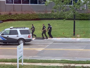 Armed police officers and others are seen outside STEM School Highlands Ranch, a charter middle school in the Denver suburb of Highlands Ranch, Colo., after a shooting Tuesday, May 7, 2019. Authorities said several people were injured and a few suspects were in custody.