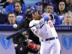 Los Angeles Dodgers' Justin Turner hits a solo home run as Atlanta Braves catcher Tyler Flowers watches along with home plate umpire Andy Fletcher during the first inning of a baseball game, Tuesday, May 7, 2019, in Los Angeles.