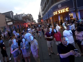 People gather to watch on Bourbon Street at Bienville Street after a Louisiana state trooper shot a driver of a car on tourist-filled Bourbon Street in the French Quarter of New Orleans, on Thursday, May 30, 2019.