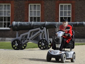 In this May 7, 2019, photo, Chelsea Pensioner and D-Day veteran George Skipper arrives on his mobility scooter for an interview with The Associated Press at the Royal Hospital in Chelsea, London, Tuesday, May 7, 2019. With the number of survivors dwindling every year, men like Skipper are on a mission to share their experiences.