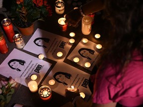 FILE - In this Tuesday, Oct. 16, 2018 file photo, people take part in a vigil to commemorate slain investigative journalist Daphne Caruana Galizia outside the law courts in Valletta, Malta. Council of Europe lawmakers have criticized the investigation into the assassination of a leading Maltese investigative journalist and calling for a public inquiry in the case. The report adopted Wednesday, May 29, 2019 by a committee of the People's Assembly of the Council of Europe says investigations into the Oct. 16, 2017, slaying of Daphne Caruana Galizia "are proceeding at a glacial pace."