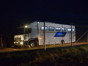 A family are transported to a transit zone for asylum seekers by police bus, in Roszke, Hungary, Tuesday, May 7, 2019. Hungary has deported a family of six asylum-seekers to Serbia, making them cross a gate in the border fence in the dark, with no one waiting for them on the Serbian side. A Hungarian human rights group said they had secured an interim measure to stop the deportation of one of two other families awaiting a similar fate.
