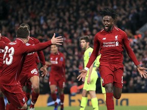 Liverpool's Divock Origi, right, celebrates scoring his side's fourth goal of the game during the Champions League Semi Final, second leg soccer match between Liverpool and Barcelona at Anfield, Liverpool, England, Tuesday, May 7, 2019.