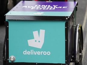 FILE - In this Tuesday, July 11, 2017 file photo, a Deliveroo logo is seen on a bicycle in London. Amazon is investing in British meal delivery company Deliveroo, expanding its reach into food retailing. Deliveroo said Friday May 17, 2019 that it raised $575 million from investors led by Amazon.