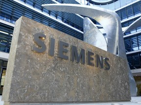 FILE - This June 24, 2016 file photo shows the logo of German industrial conglomerate Siemens at the new headquarters in Munich, Germany. German industrial equipment maker Siemens said Tuesday May 7, 2019, it will cut some 10,000 jobs in a major restructuring that will involve spinning off its oil, gas and power generation business and creating new areas of growth.