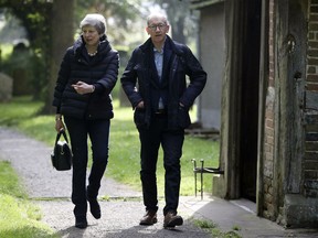 Britain's Prime Minister Theresa May with her husband Philip leave after a church service near her Maidenhead constituency, England, Sunday May 19, 2019.