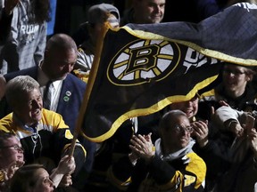 Boston Bruins great Bobby Orr, left, smiles as he waves a team flag with fans prior to Game 2 of the NHL hockey Stanley Cup Eastern Conference final against the Carolina Hurricanes, Sunday, May 12, 2019 in Boston.