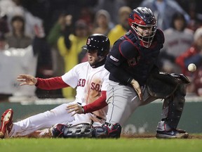 Cleveland Indians catcher Roberto Perez, right, tries to control the ball as Boston Red Sox's Michael Chavis, left, scores on a double by Steve Pearce in the eighth inning of a baseball game at Fenway Park in Boston, Tuesday, May 28, 2019.