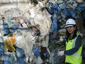 Yeo Bee Yin, Malaysia's minister of energy, science, technology, environment and climate change, left, speaks to members of the media, not pictured, while displaying containers filled with plastic waste at Port Klang, Selangor, Malaysia on May 28, 2019.