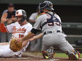 Baltimore Orioles' Trey Mancini, left, is safe at the plate, as Detroit Tigers catcher John Hicks tries to make the tag, on a double by Renato Nunez during the first inning of a baseball game Wednesday, May 29, 2019, in Baltimore.