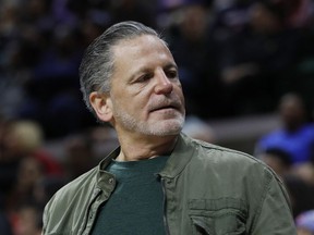 FILE- In an Oct. 12, 2018 file photo, Quicken Loans and Rock Ventures founder Dan Gilbert is seen during a basketball game in East Lansing, Mich. Gilbert is starting a ballot drive as a "failsafe" in case Michigan's Republican-led Legislature and Democratic Gov. Gretchen Whitmer don't enact legislation to cut the country's highest auto insurance premiums. Quicken Loans vice president of government affairs Jared Fleisher said Monday that a ballot committee, Citizens for Lower Auto Insurance Rates, will be created this week.