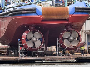 In this Thursday, May 16, 2019 photo a worker walks beside ship's screws at a dockyard at the harbor in Bremerhaven, Germany. The city became a battleground for EU's fragile political center, support for Germany's Social Democrats has ebbed dramatically in recent years, but nowhere is their fate more closely watched than in the tiny city-state of Bremen.