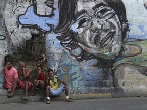 A group of young people rest in a hole in the wall at the Agua Salud neighborhood of Caracas, Venezuela, Wednesday, May 15, 2019. More than 3 million Venezuelans have left their homeland in recent years amid skyrocketing inflation and shortages of food and medicine. U.S. administration officials have warned that 2 million more are expected to flee by the end of the year if the crisis continues in the oil-rich nation.