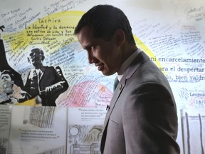Venezuela's opposition leader Juan Guaidó, who declared himself the interim-president of Venezuela, stands next to a mural at the Popular Will party's headquarters, in Caracas, Venezuela, Friday, May 10, 2019. In an interview Friday with The Associated Press, Guaidó repeated his willingness to consider inviting foreign troops to force Nicolas Maduro from power, echoing the line from Washington that "all options" are on the table for dealing with Venezuela's rapidly-escalating crisis.
