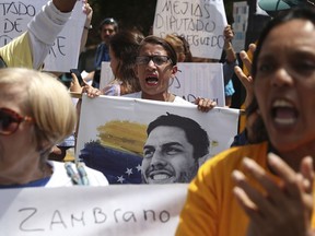 A woman holds an image of jailed opposition lawmaker and outspoken critic of President Nicolas Maduro, Juan Requesens, as she chants with others in support of the opposition controlled National Assembly, in Caracas, Venezuela, Thursday, May 16, 2019. Diplomatic efforts aimed at resolving Venezuela's crisis accelerated on Thursday as the government and opposition sent envoys to negotiate in Norway, though the two sides' mutual mistrust and differences on key issues could prevent any quick solution.
