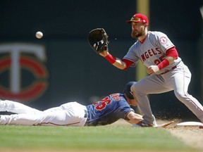 Minnesota Twins' Max Kepler,left, drives safely back to first base as Los Angeles Angels first baseman Jared Walsh, making his major league debut, awaits the ball in a baseball game Wednesday, May 15, 2019, in Minneapolis.