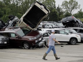 A worker walks past tornado-damaged Toyotas at a dealership in Jefferson City, Mo., Thursday, May 23, 2019, after a tornado tore though late Wednesday.