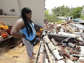 Iesha McClain looks through her destroyed home Thursday, May 23, 2019 after a tornado tore though Jefferson City, Mo. late Wednesday.