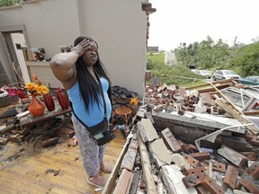 Iesha McClain looks through her destroyed home Thursday, May 23, 2019 after a tornado tore though Jefferson City, Mo. late Wednesday.