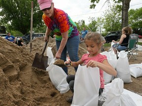 Barbara Moore, left, and her granddaughter Amaya Ward, 7, fill sandbags with other volunteers at the Cherokee Lakes Campground in O'Fallon, Mo., Tuesday, May 7, 2019. The levee at the campground began leaking around 3 a.m. and the owners of the campground put out a call to friends and volunteers to come help fill sandbags to shore up the levee to keep it from failing.